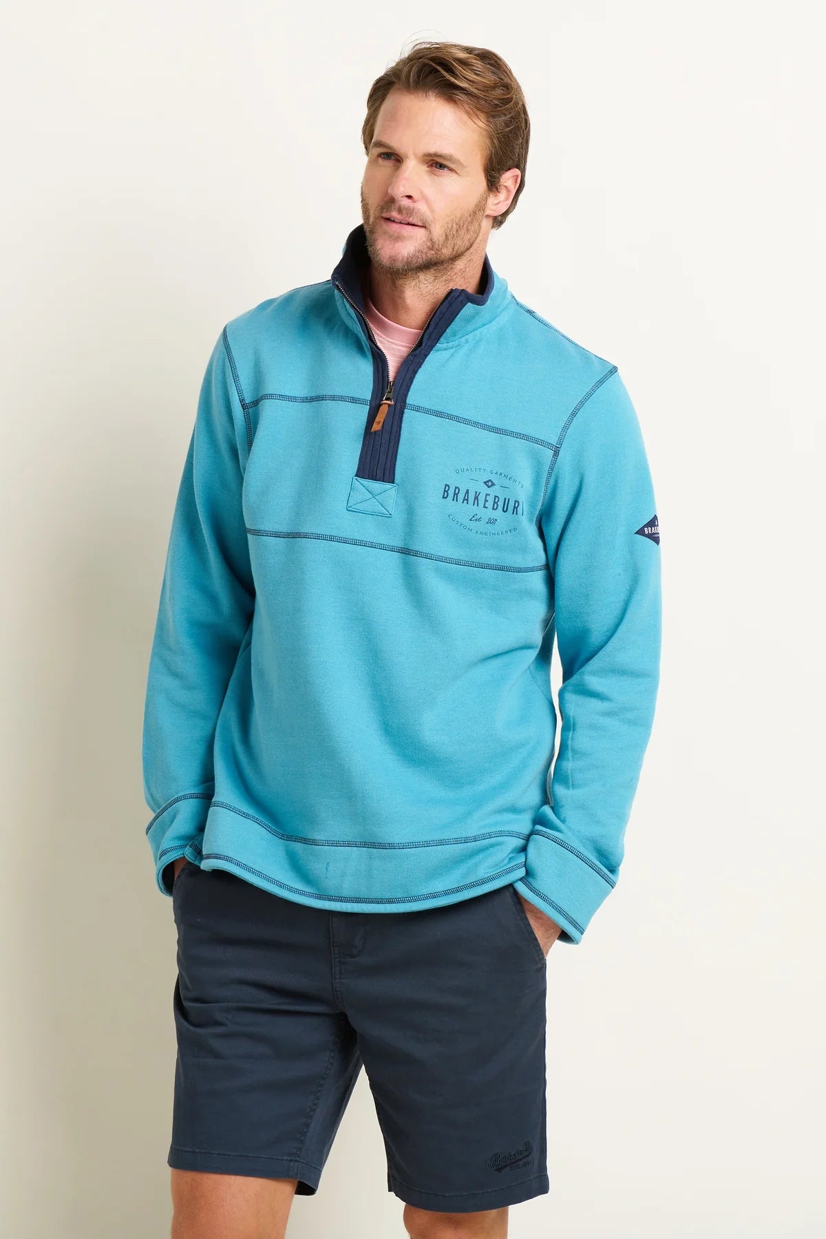 Brakeburn mens blue sweatshirt with quarter zip and logo on chest worn by male model
