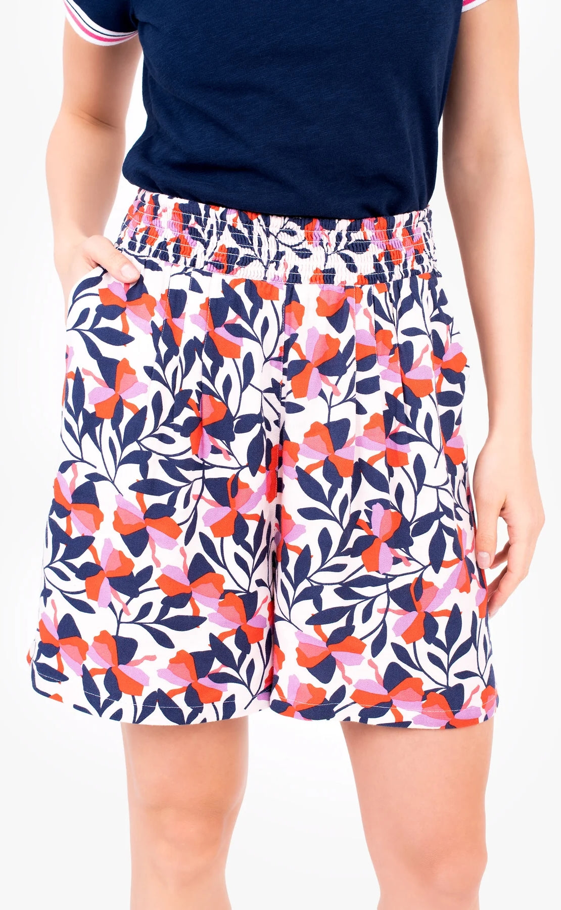 Woman wearing Pink Gardinia floral loose fit shorts with elastic eawist, worn with a navy t-shirt