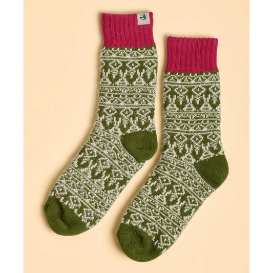 Pair of womens Brakeburn green Nordic patterned socks with pink cuffs on a beige background