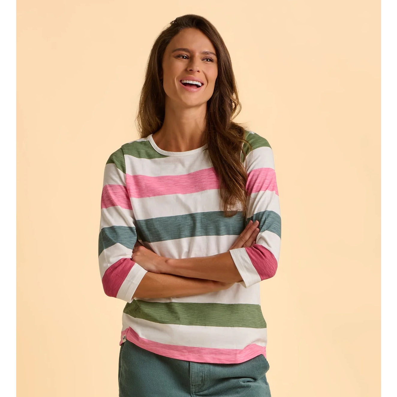 Woman wearing a striped long-sleeve t-shirt against a beige background