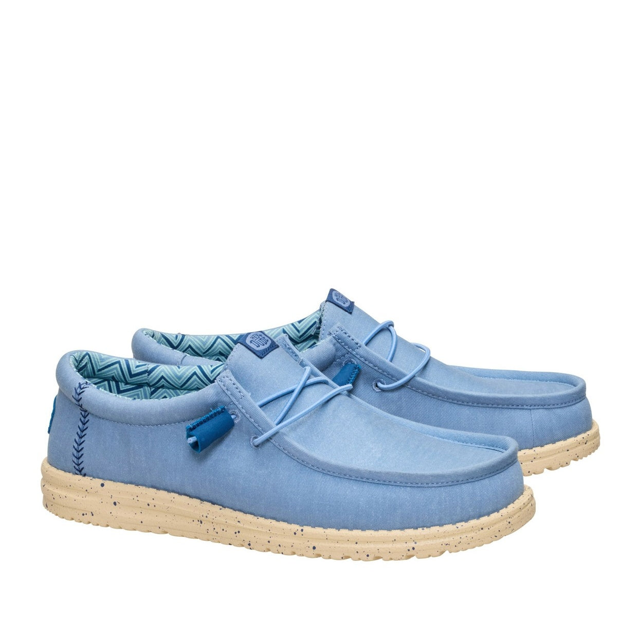 A pair of men's Dude Wally Stretch Canvas lightweight shoes in Faded Denim Blue / Boulder Tan, with elastic laces and speckled soles.