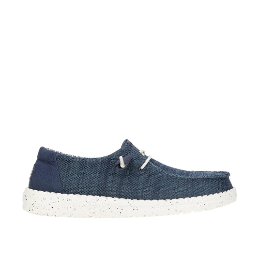 Side view of a women's Dude Wendy Stretch Sox shoe in Navy, featuring a white sole, elastic laces and plain brown heel panel.