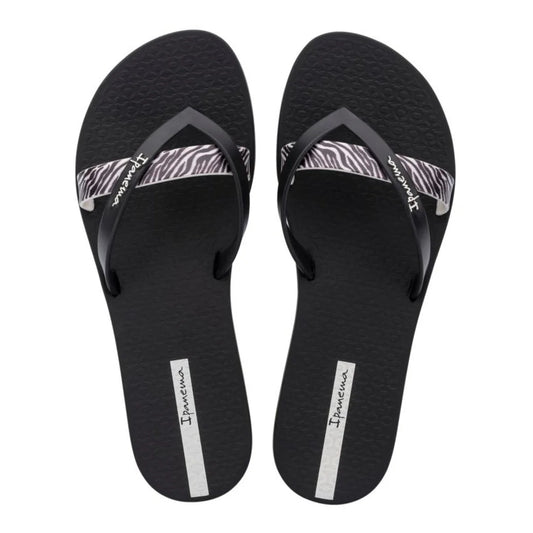 Top view of a pair of women's Ipanema Kirei flip flops, a three strap toepost design in black with a contrasting zebra print strap and textured footbed.