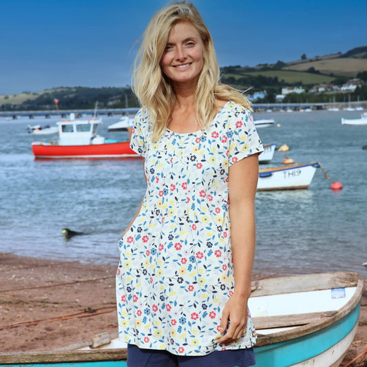 Lazy Jacks womens floral tunic in a sunny seaside setting with colorful patterns and pockets