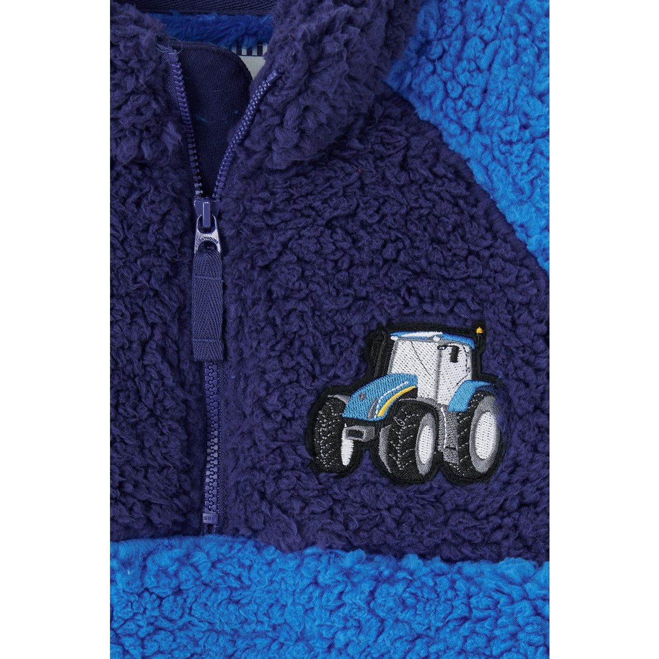 Navy and blue Lighthouse Caden fleece jacket with a tractor design on a white background