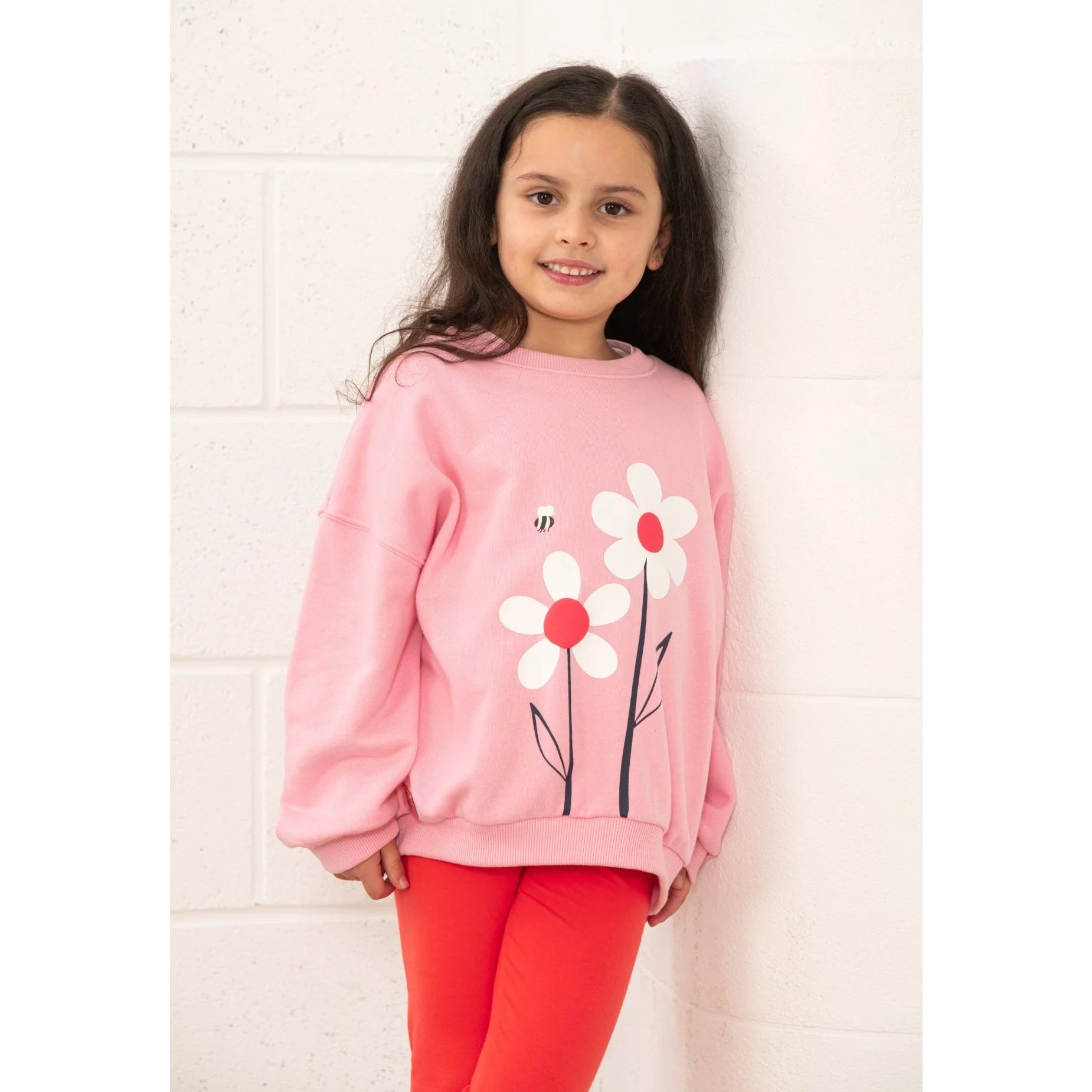 Front view of a Lighthouse kids Flora sweatshirt Dusky Pink flowers with white floral design worn by girl