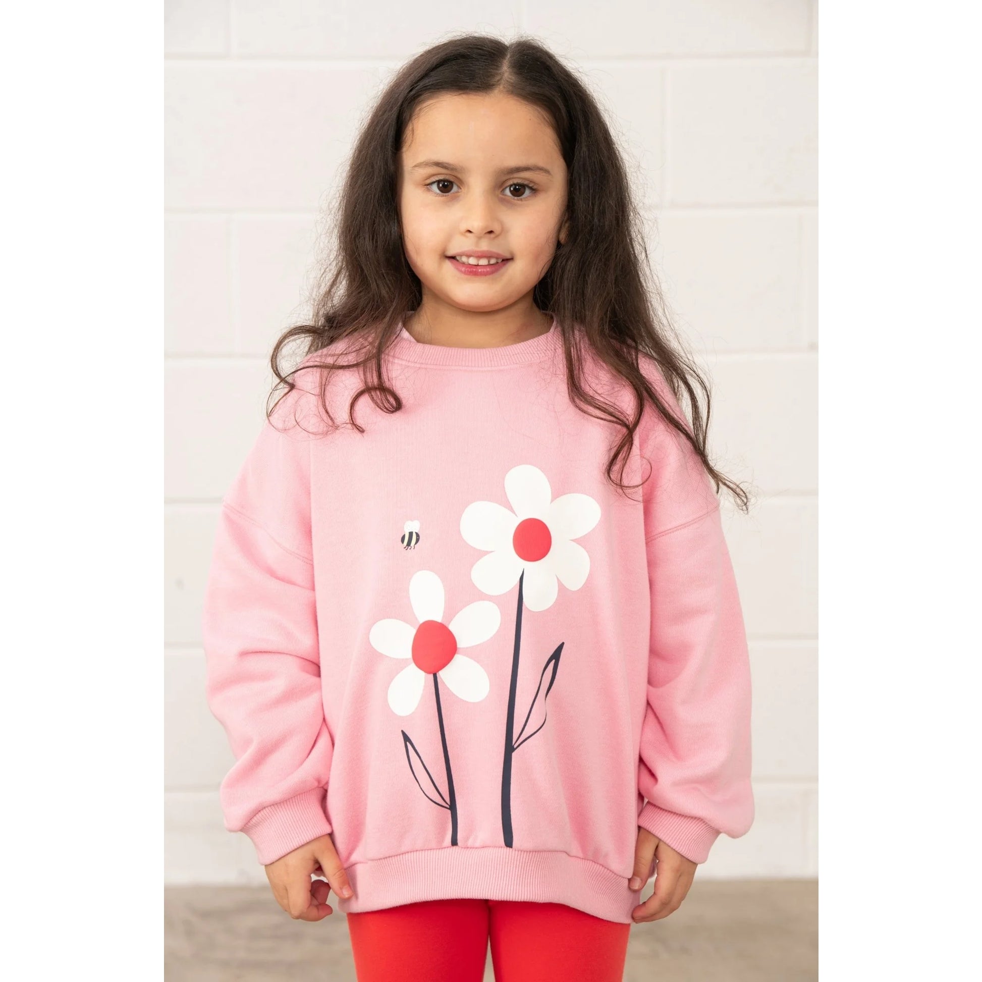 Lighthouse kids Flora sweatshirt Dusky Pink flowers worn by girl with long hair smiling