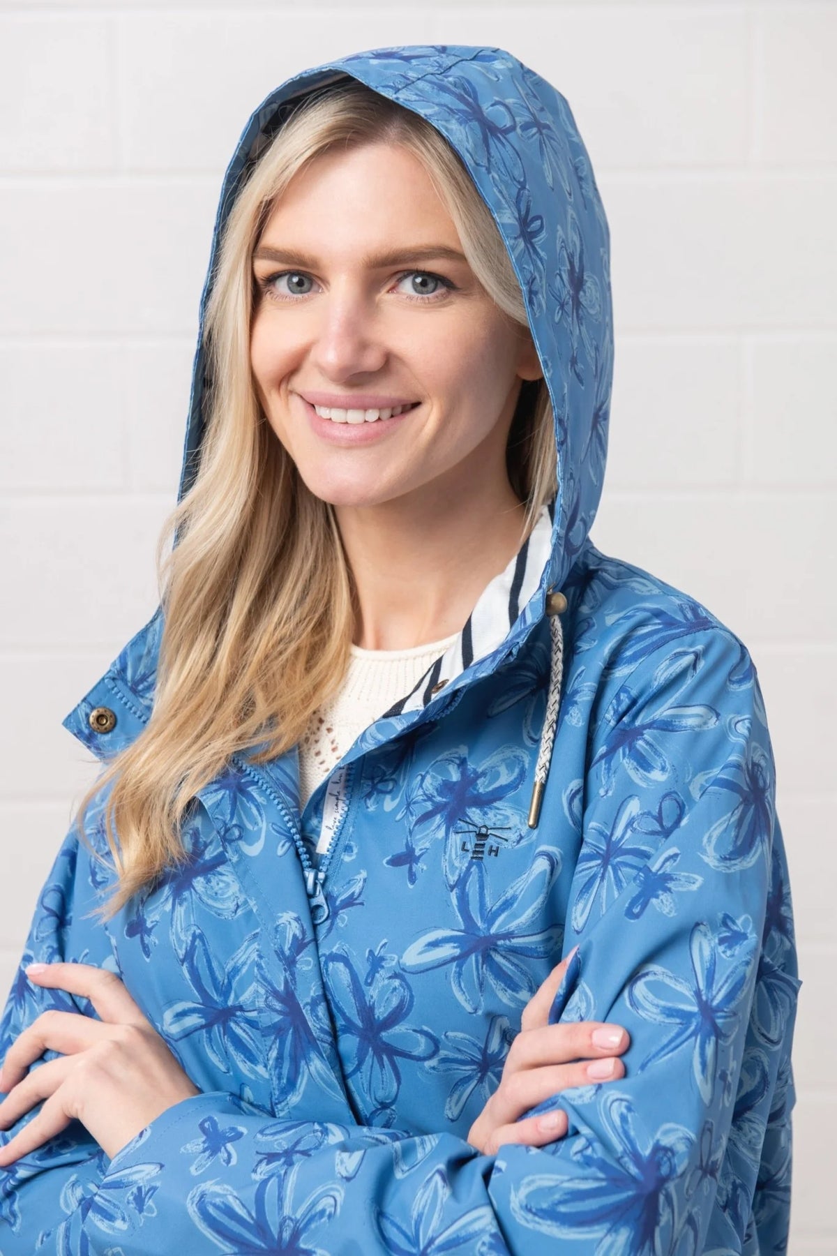 Lighthouse Womens blue floral jacket with hood worn by smiling blonde woman indoors