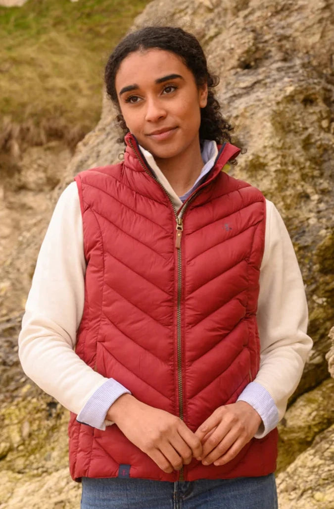 Lighthouse womens Laurel padded gilet red worn by woman outdoors with zip front and quilted design
