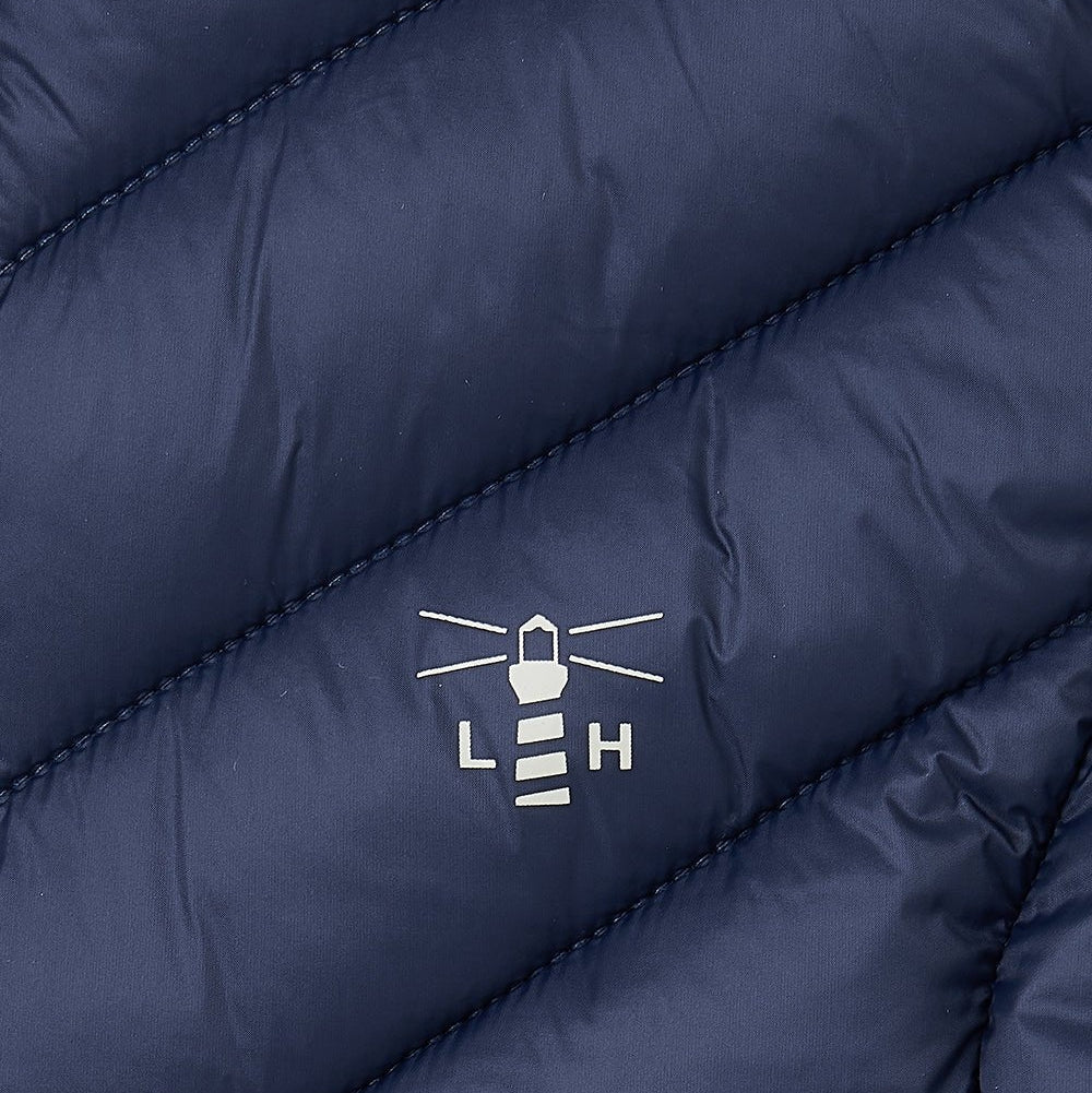 Close-up of a navy blue Lighthouse Laurel padded gilet with a logo on the chest.