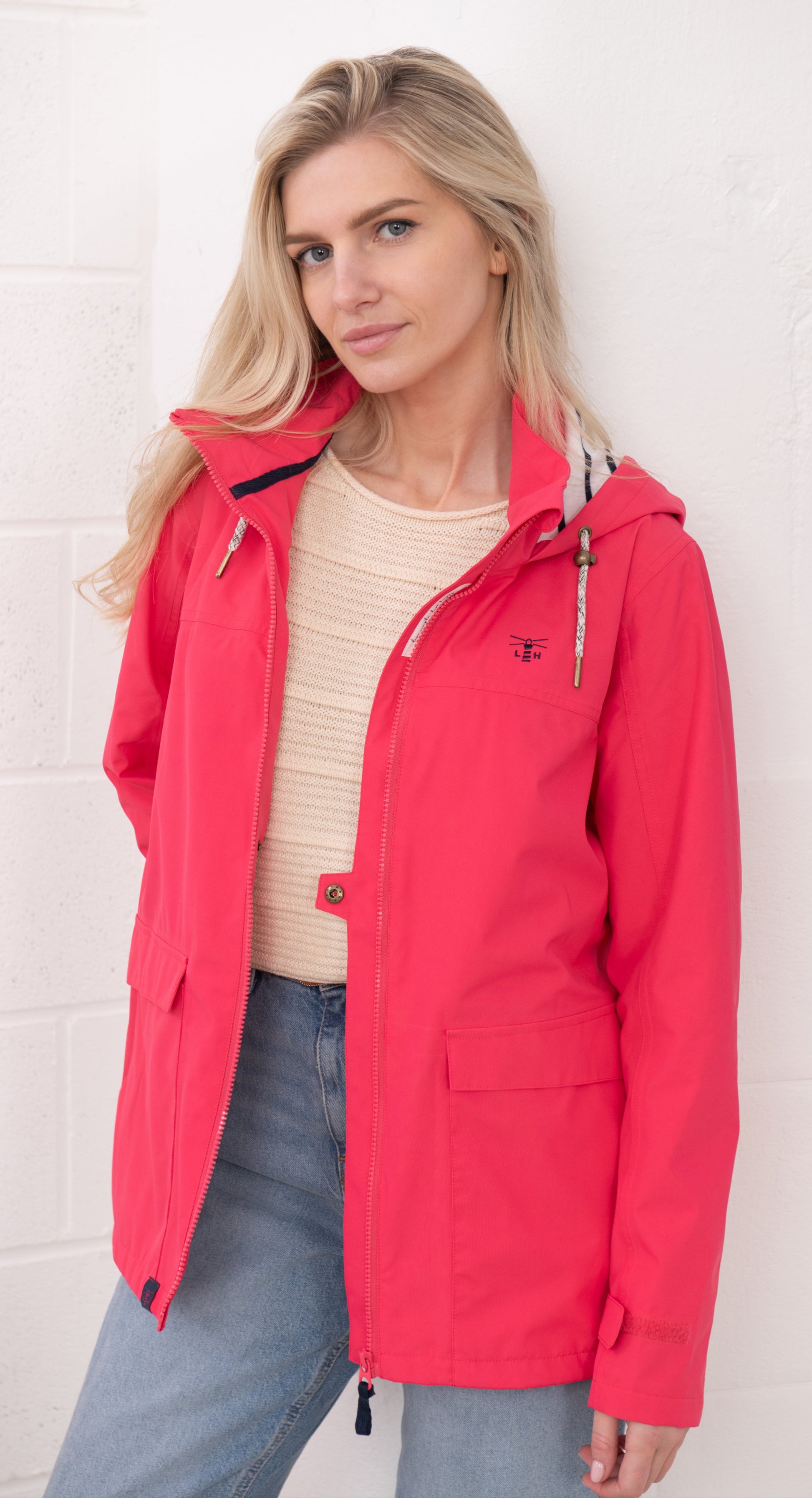 Lighthouse womens waterproof jacket raspberry worn by model with hood and front pockets