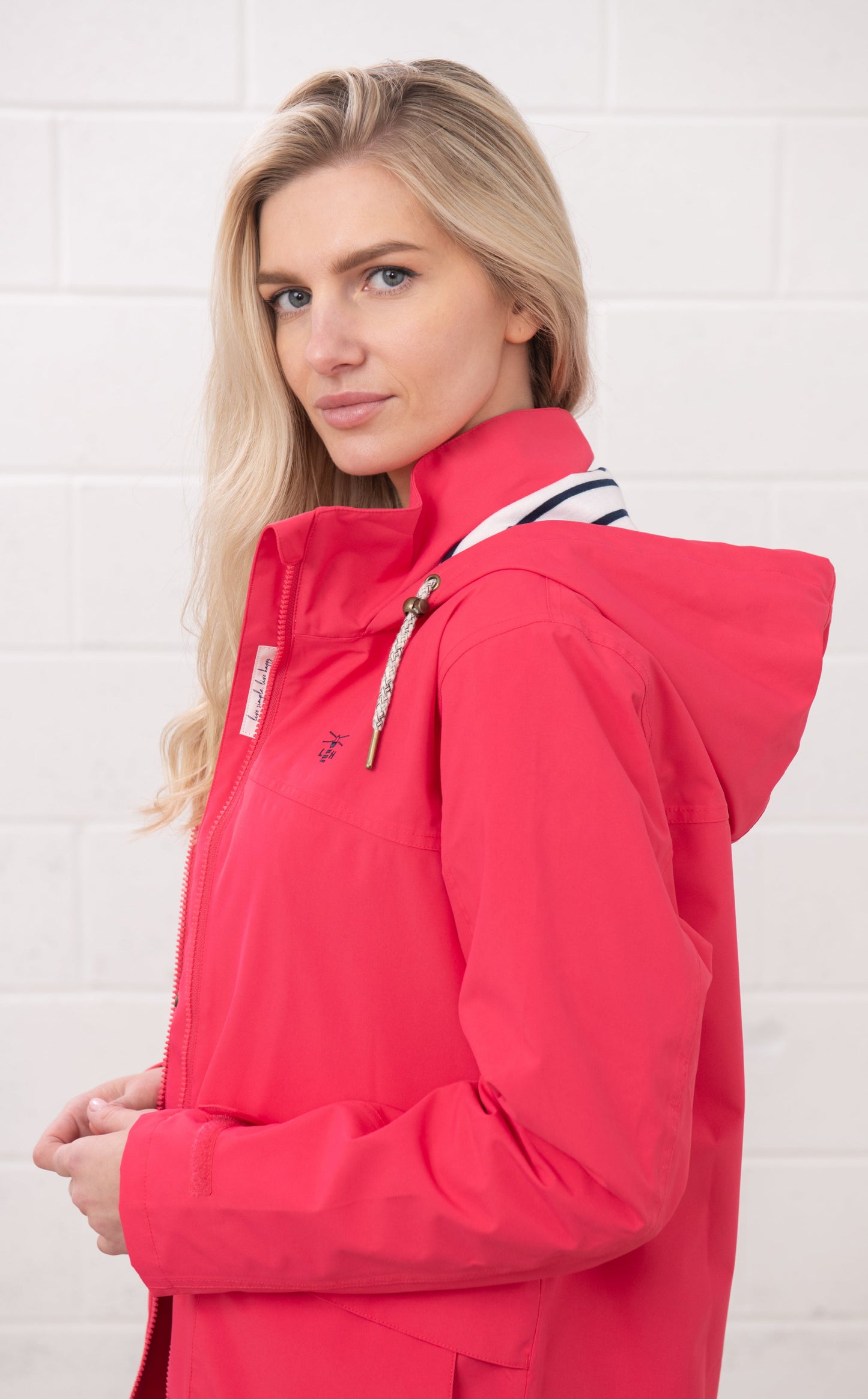 Lighthouse womens waterproof jacket raspberry with hood and front zipper on blonde model