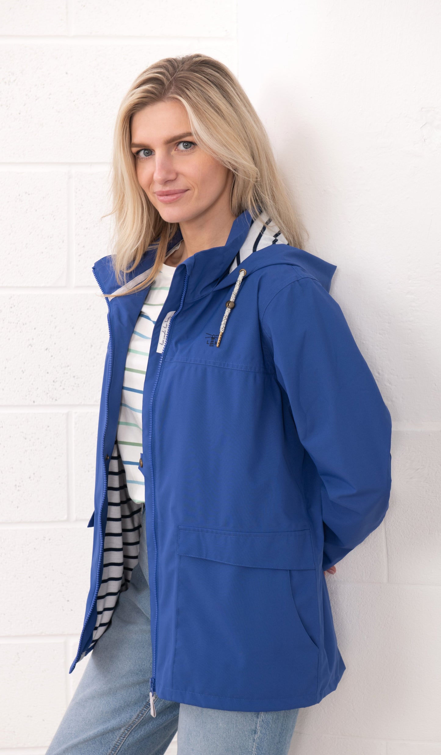Lighthouse womens waterproof jacket in blue with hood and front pockets worn by model