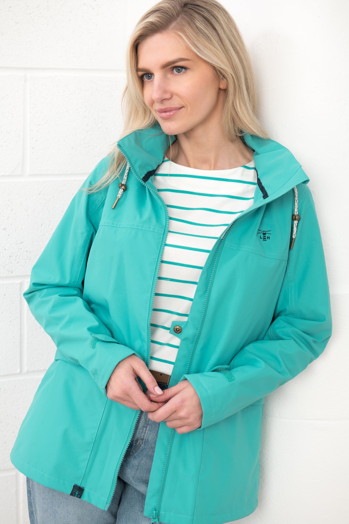 Lighthouse womens waterproof jacket teal worn by woman with striped shirt and jeans