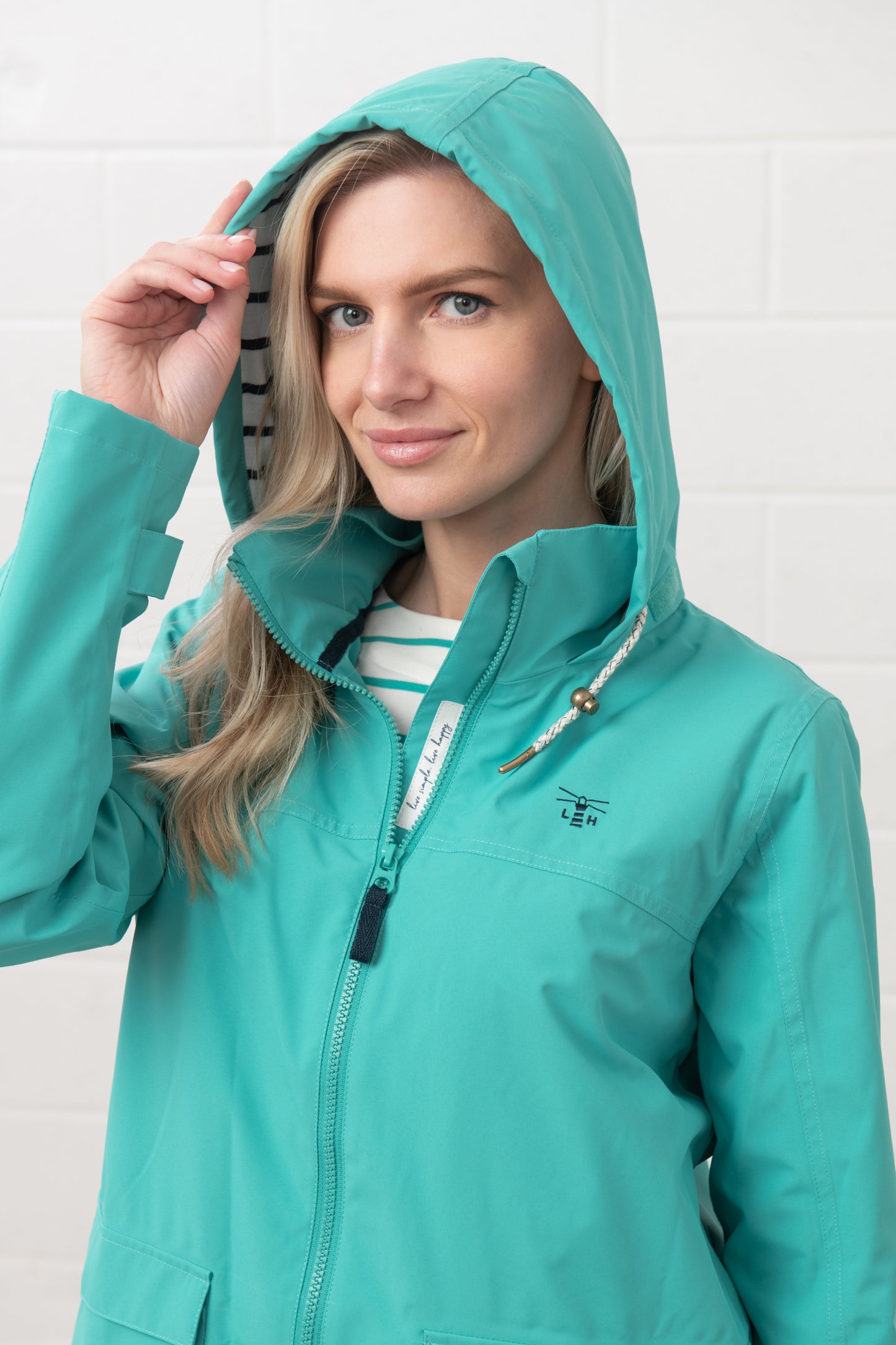 Lighthouse womens waterproof jacket teal with hood and zip front on model