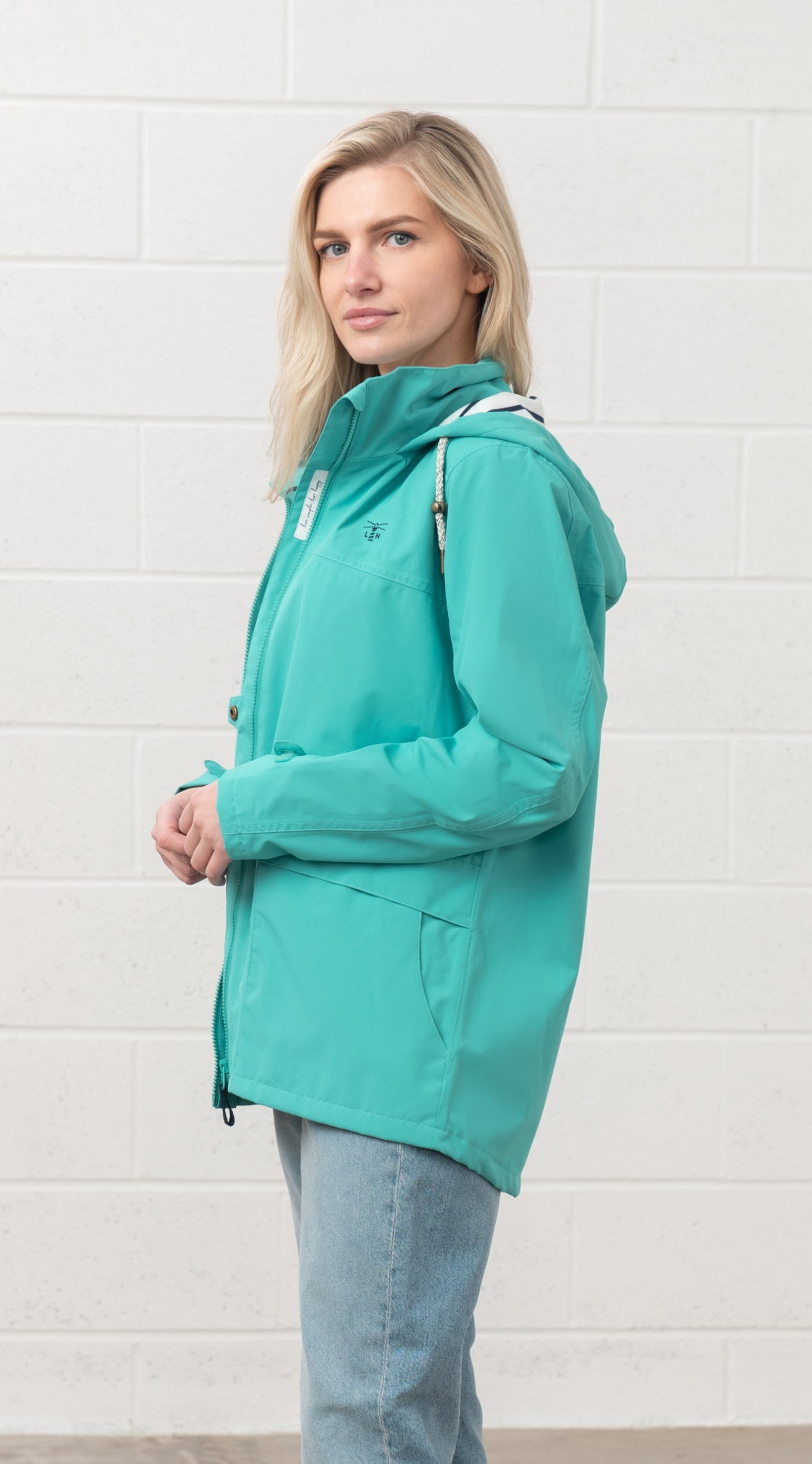 Lighthouse womens waterproof jacket teal worn by woman with hood and zip front