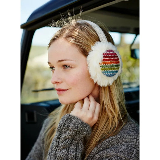 Woman wearing colourful pair of knitted Pachamama ear muffs sitting inside a vehicle.