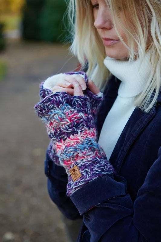 Woman wearing a pair of Pachamama knitted Utrecht hand warmers in pink and purple with a Sherpa lining