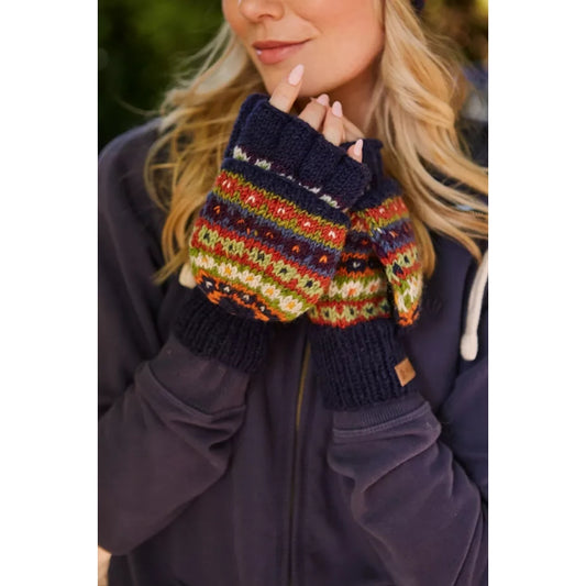 Woman wearing colourful knitted Pachamama Colorado fingerless glove mittens with a dark coat.