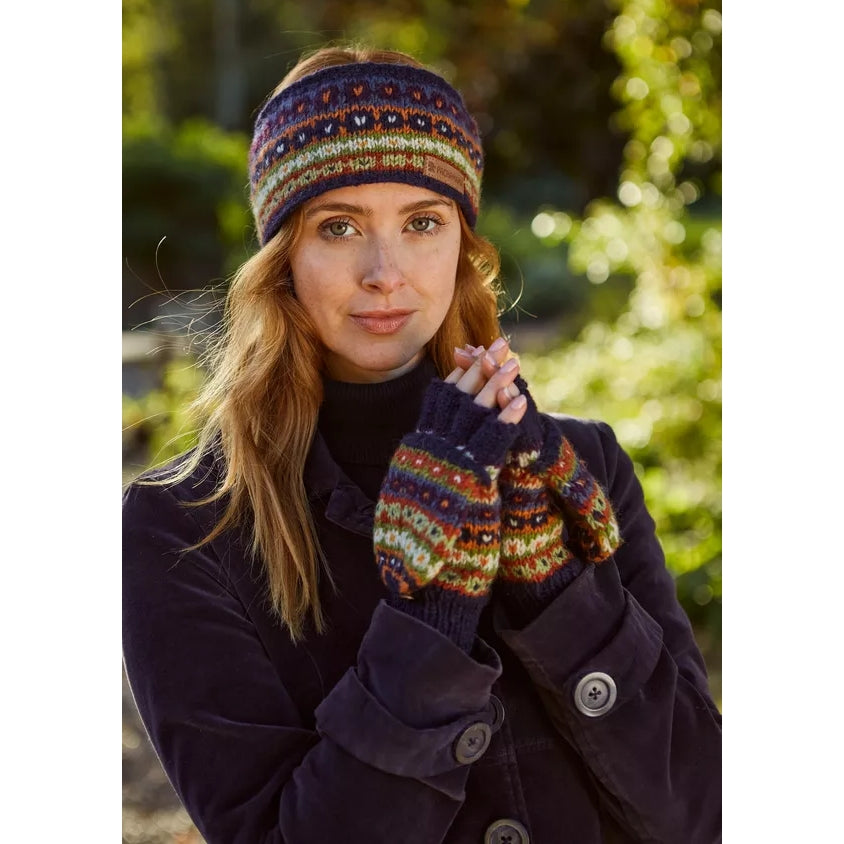 Woman wearing a dark coat and multicolour Pachamama fingerless glove mitts outdoors