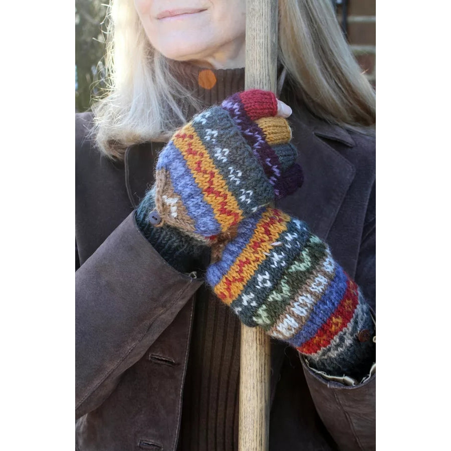 Woman wearing Pachamama Elveden fingerless glove mittens in a colourful Fair Isle pattern holding a pole outside