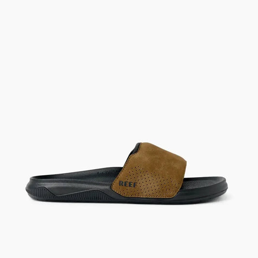Side view of a mens Reef Tailslide slider sandal in grey with a tan brown padded strap and printed strap logo.