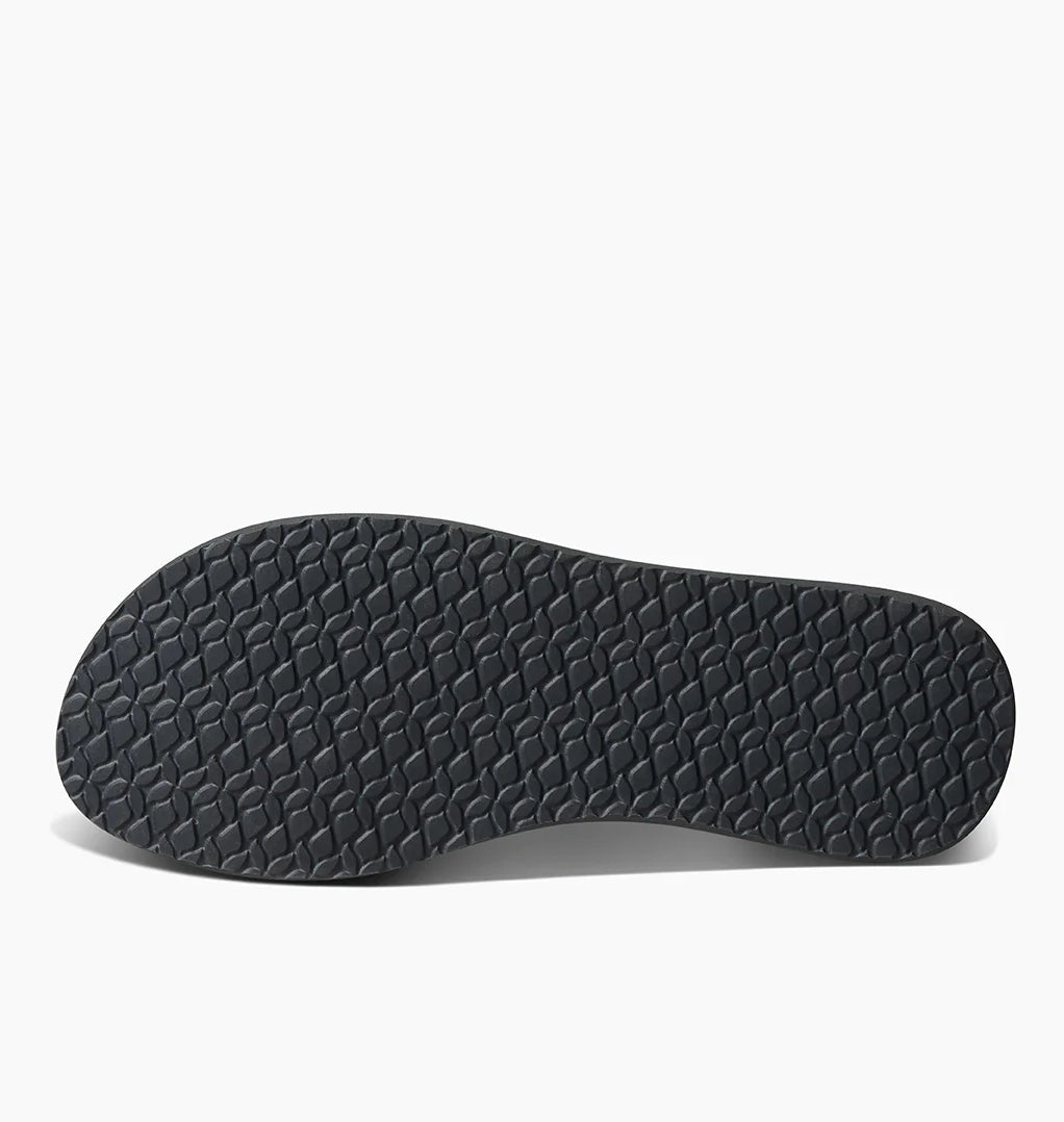Black textured sole of Reef womens Cushion Breeze flip flops showing non-slip grip pattern