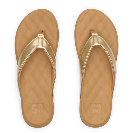 Top view of a pair of women's Reef Cushion Melody flip flops with a Champagne Gold strap and pillow textured cushioning footbed.