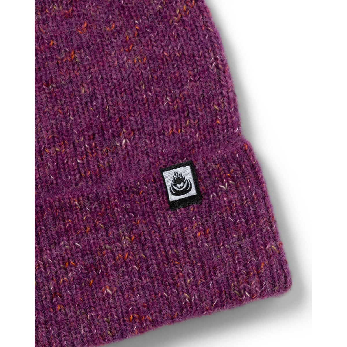 Close-up view of the turn back hem and logo label of an adults Saltrock Brushed Maine knitted beanie in purple.