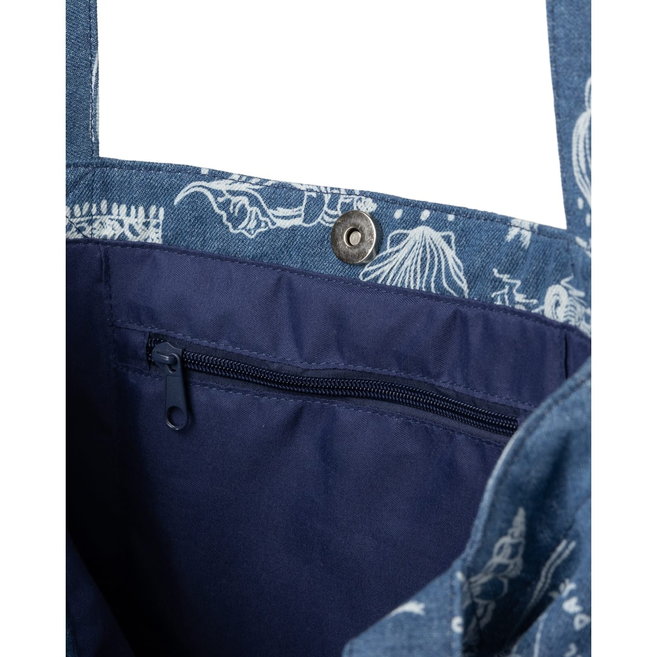 Close-up view of the internal pocket and magnetic popper closure of a Saltrock Island Life shopper bag in denim blue with a white tropical seaside print.