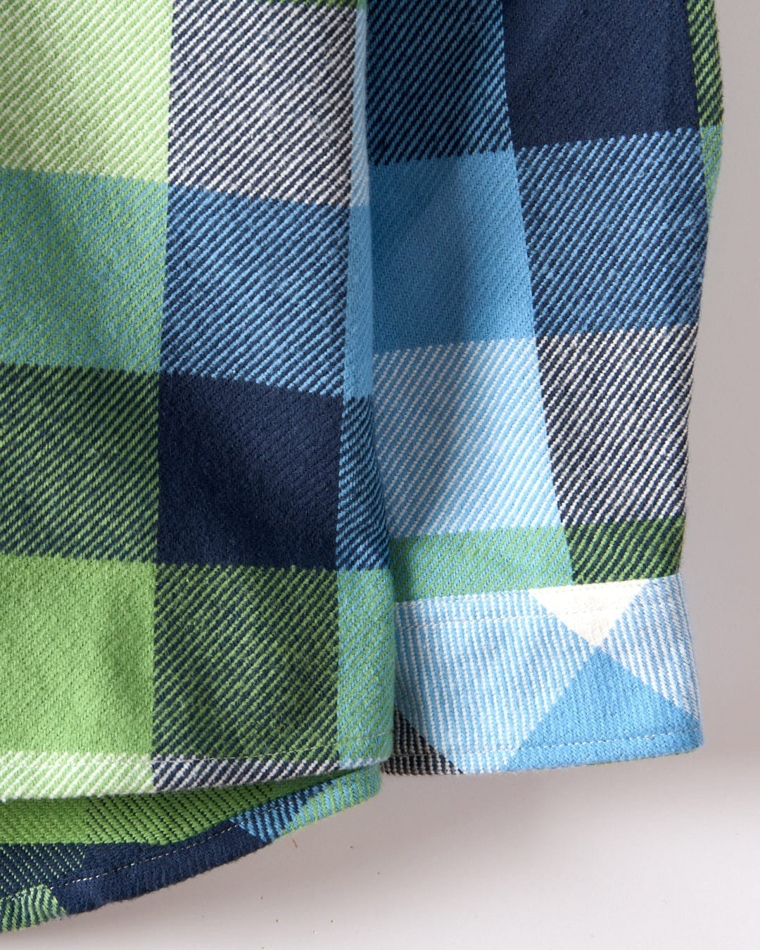 Close-up of Saltrock kids check shirt sleeve with blue green and navy plaid pattern