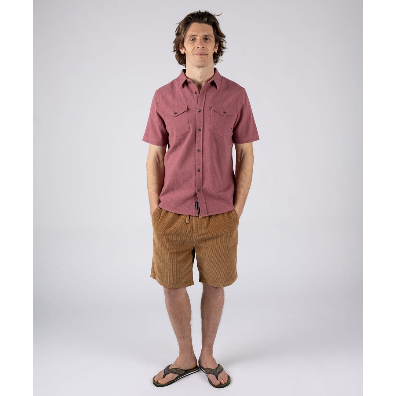 Man wearing a Saltrock dark pink short sleeve Polperro button through shirt with brown shorts and flip flops