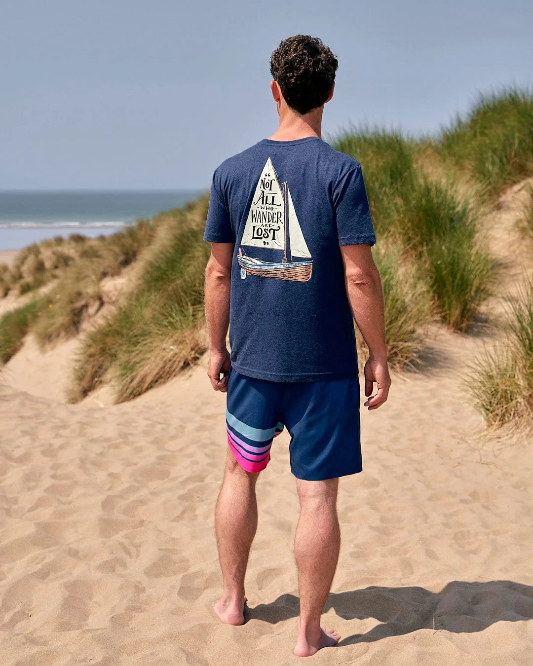 Saltrock mens tee lost ships navy blue t-shirt with sailboat graphic worn on beach