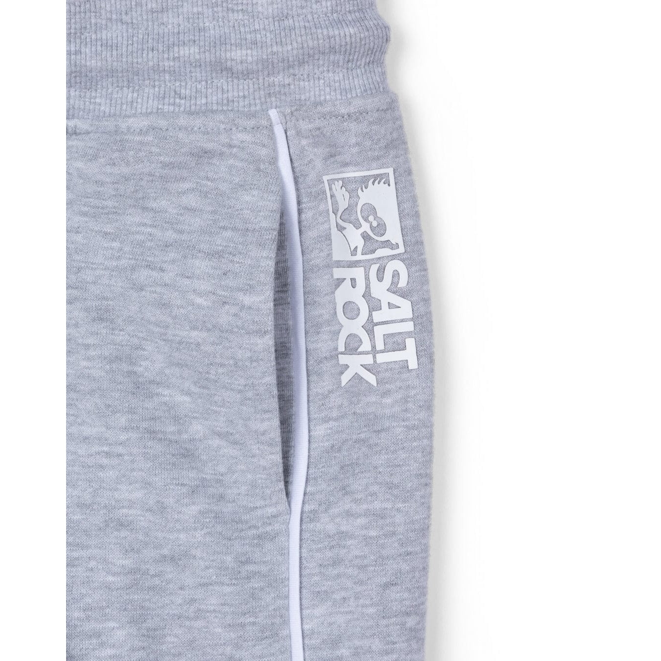Close-up view of a hip pocket and raised white logo print on kids Saltrock Tok Corp jogger trousers in grey with white piping trim