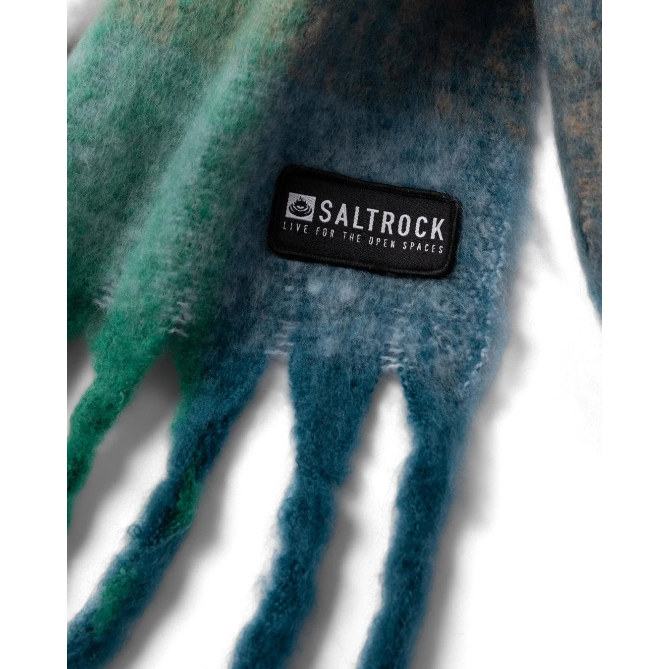 Close up of a blue and green Harvest scarf with a Saltrock logo on a white background