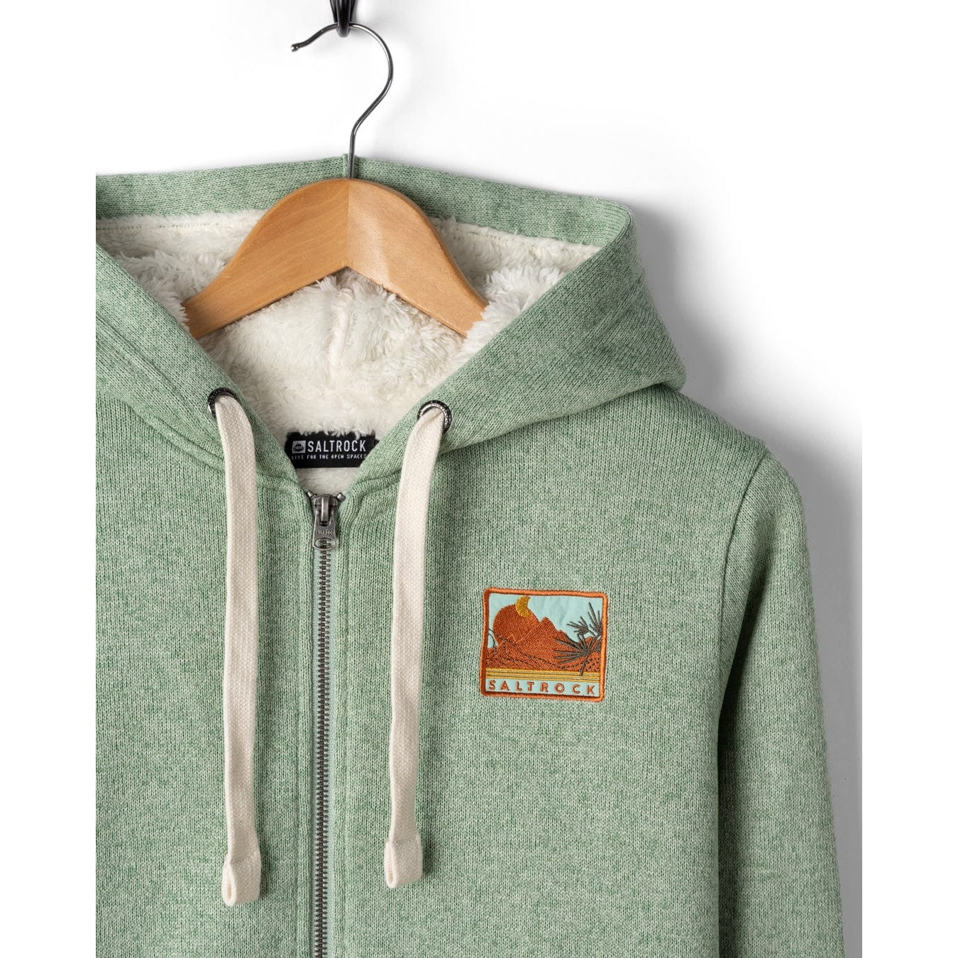 Green Saltrock Ayden hoodie with a logo on a wooden hanger against a white background