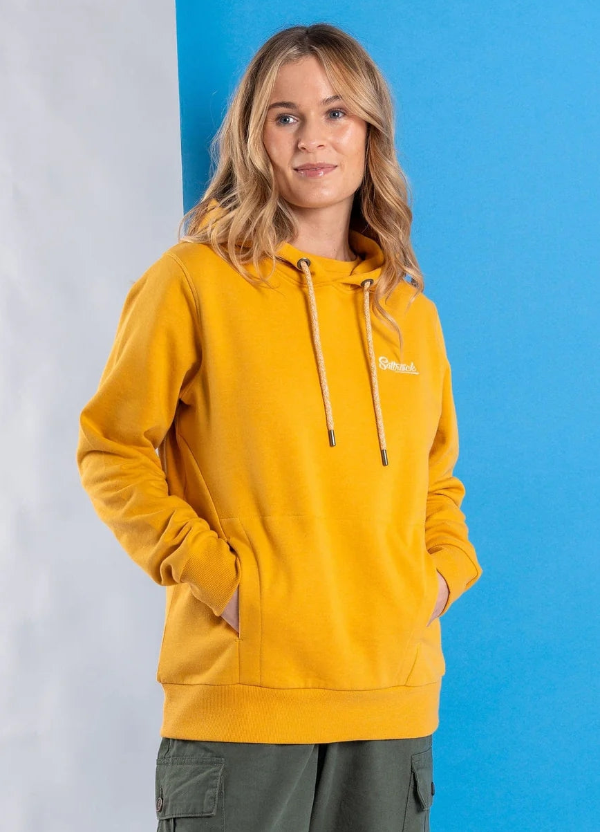 Womens Gold Yellow Hoodie Saltrock worn by a woman with hands in pockets against blue background