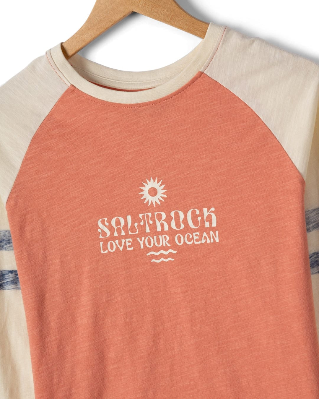 Coral and cream baseball shirt with 'Saltrock Love Your Ocean' text on a hanger.