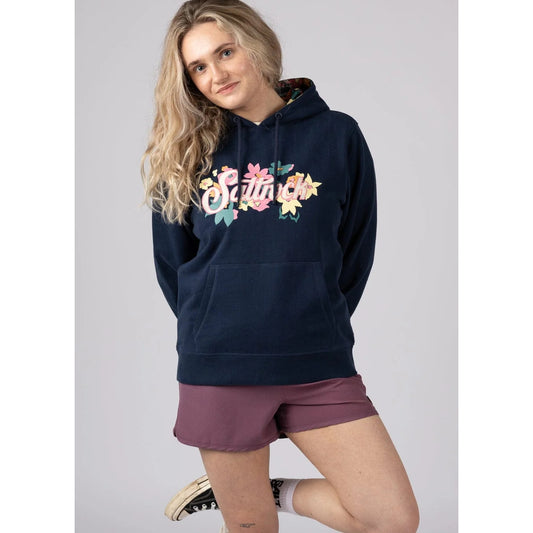 Front view of a woman wearing a navy Saltrock pop hoodie with floral logo design on a plain background