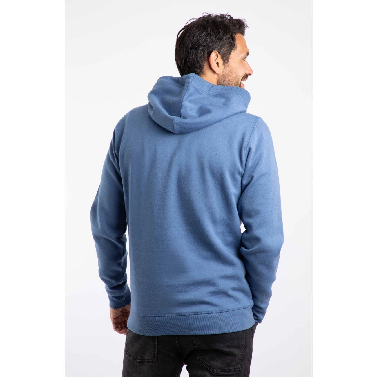 Man wearing a Weird Fish Bryant mid blue hoodie on a white background