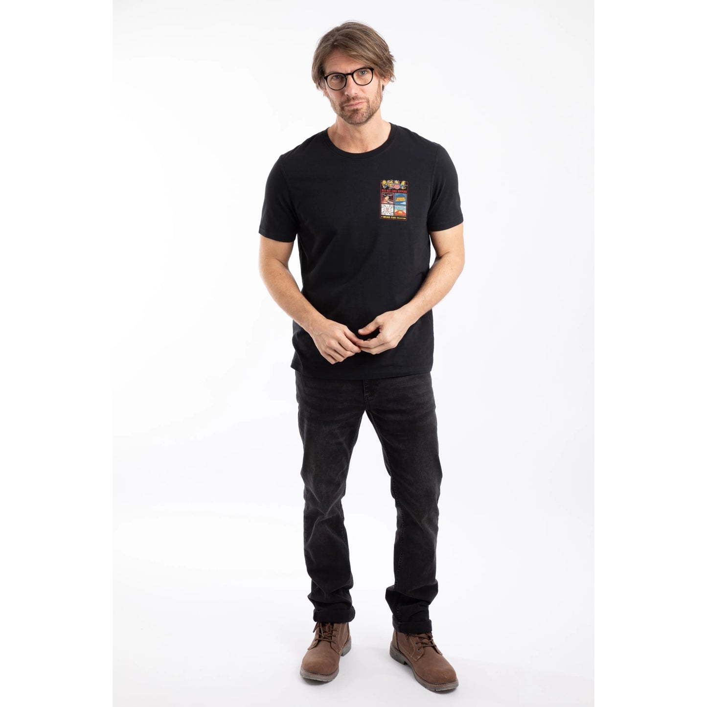 Man wearing a Weird Fish mens short sleeve Chili Kippers t-shirt in black with black jeans and brown boots.