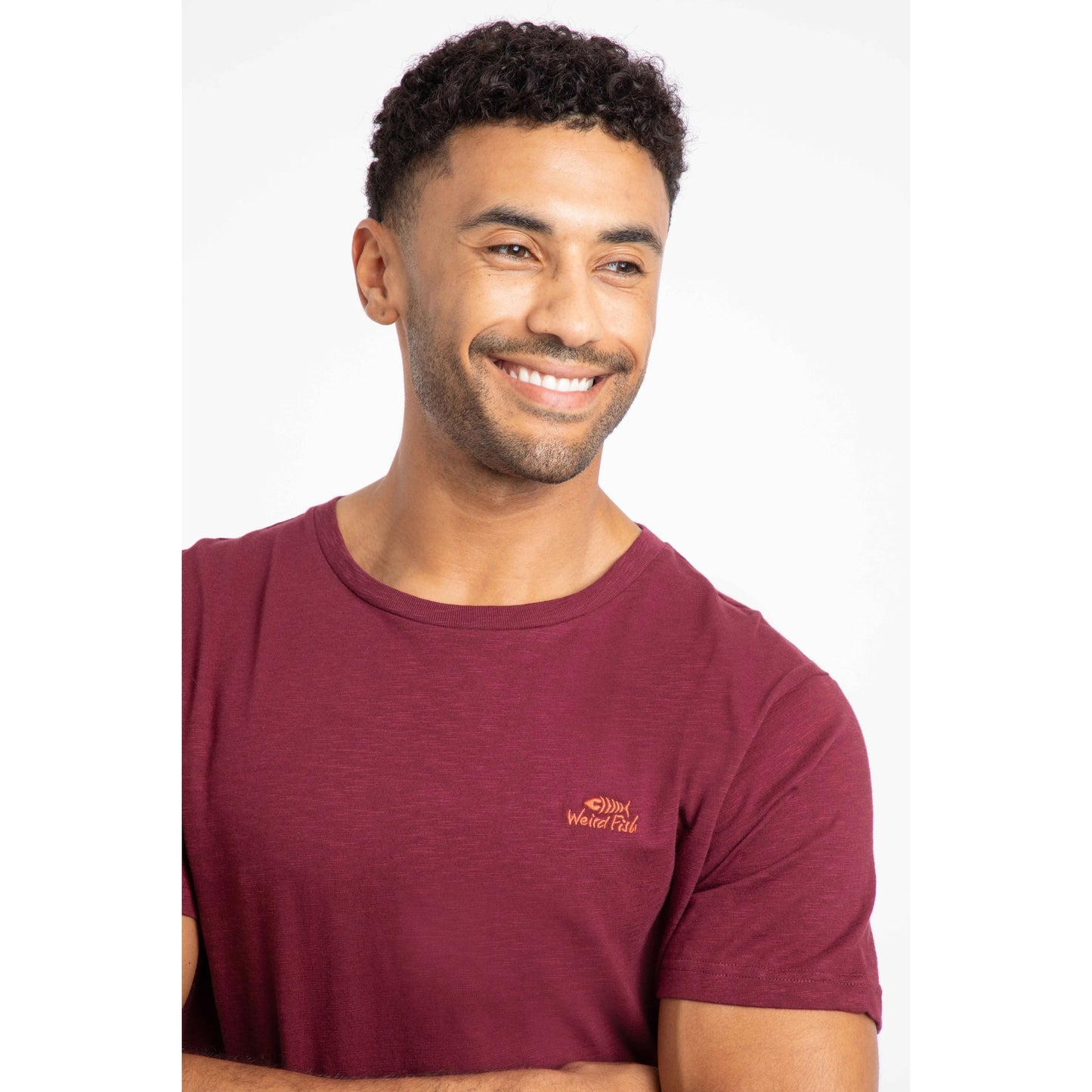 Weird Fish mens Fished t-shirt red worn by smiling man, featuring small logo on chest