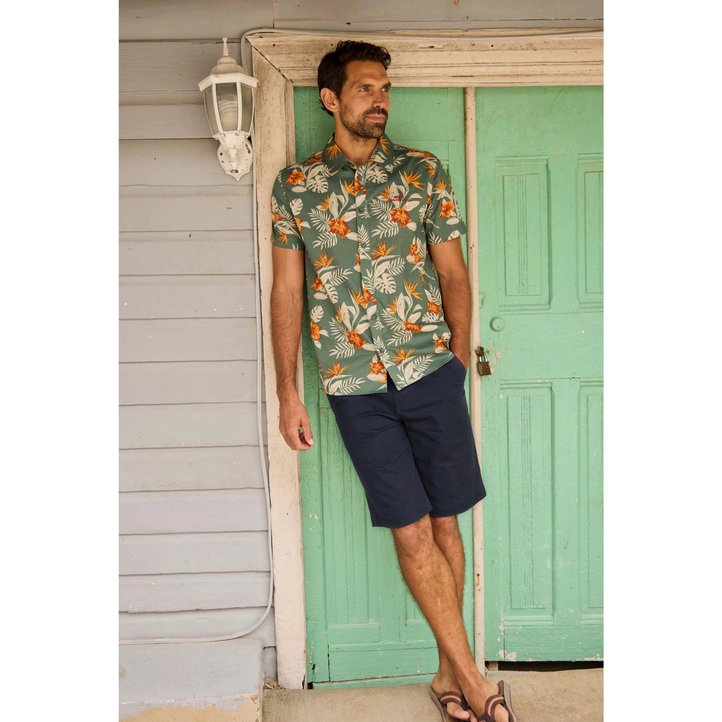 Man wearing Weird Fish mens navy Rayburn chino shorts with a tropical short sleeve shirt and sandals