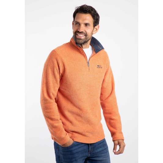 Front view of Weird Fish mens Newark grid fleece Brick Orange half zip pullover worn by man with dark hair and beard