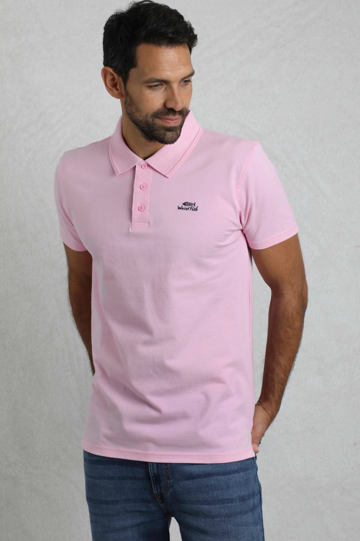 Weird Fish mens pink polo shirt worn by model with short sleeves and button collar