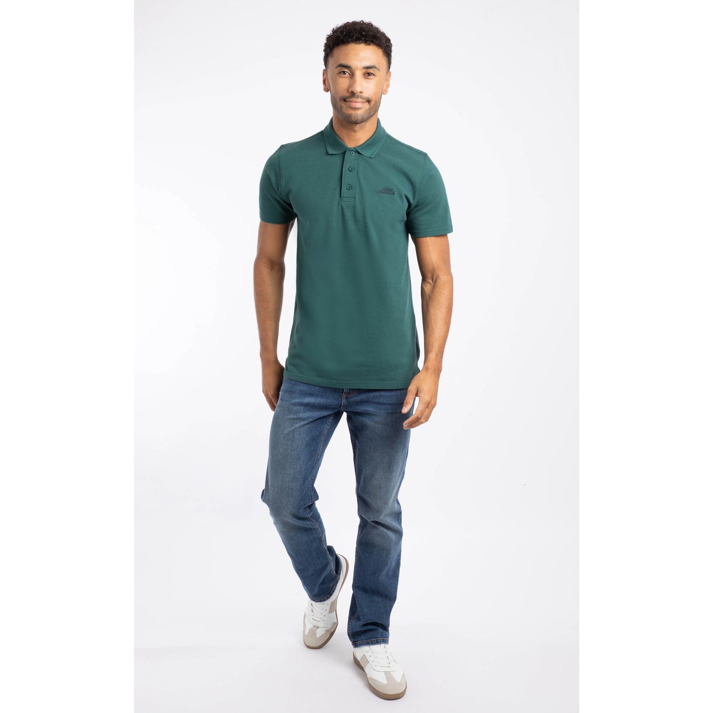 Weird Fish mens polo shirt Forest Green worn by man paired with blue jeans and white sneakers