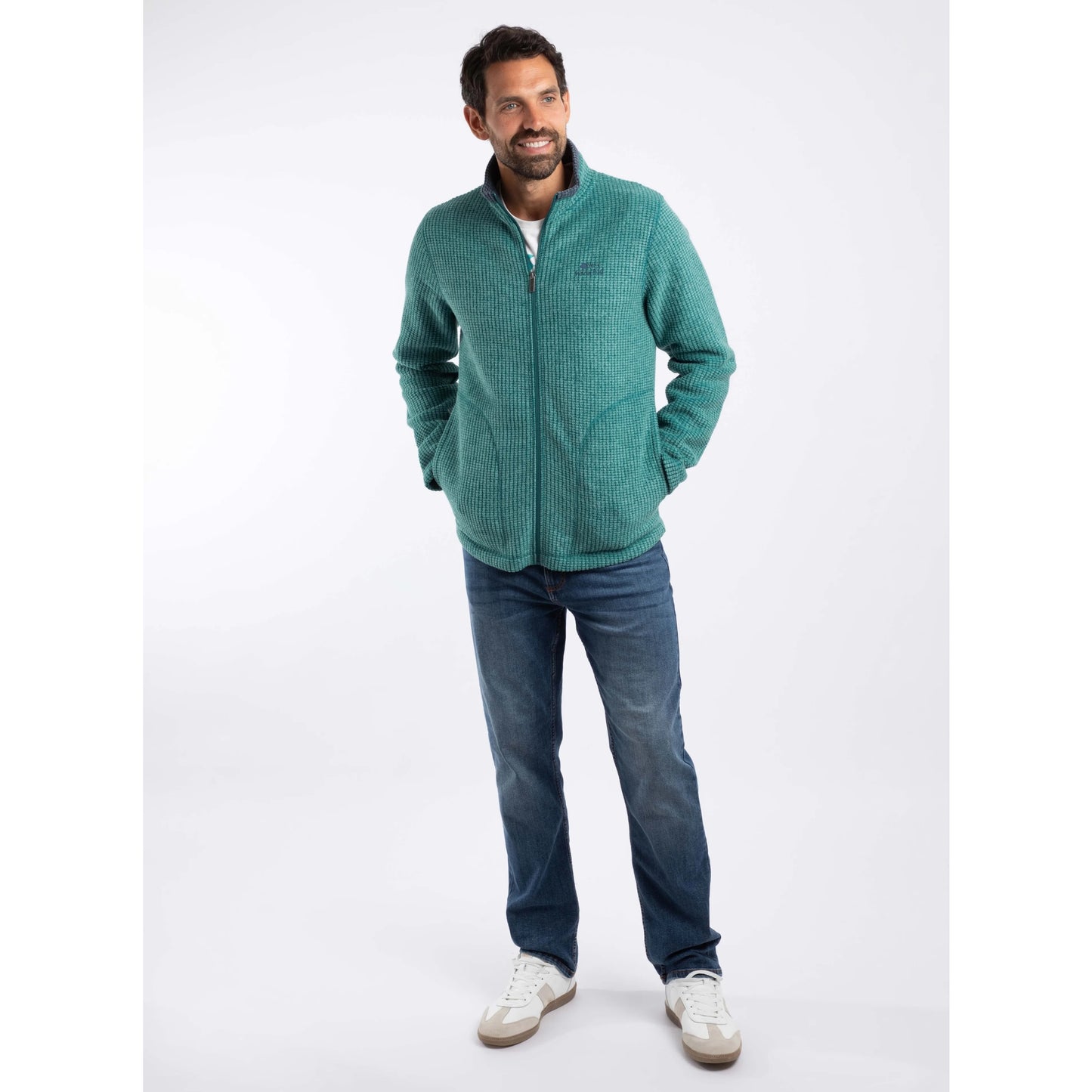 Man wearing Weird Fish mens Shires full zip grid fleece Leaf Green with jeans and white sneakers