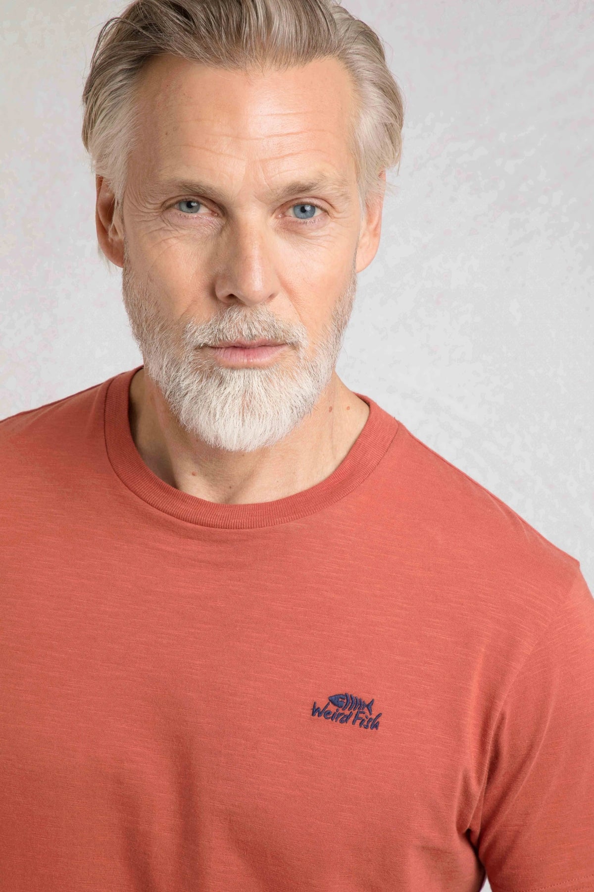 Weird Fish mens t-shirt baked clay with small logo on chest worn by man with gray beard