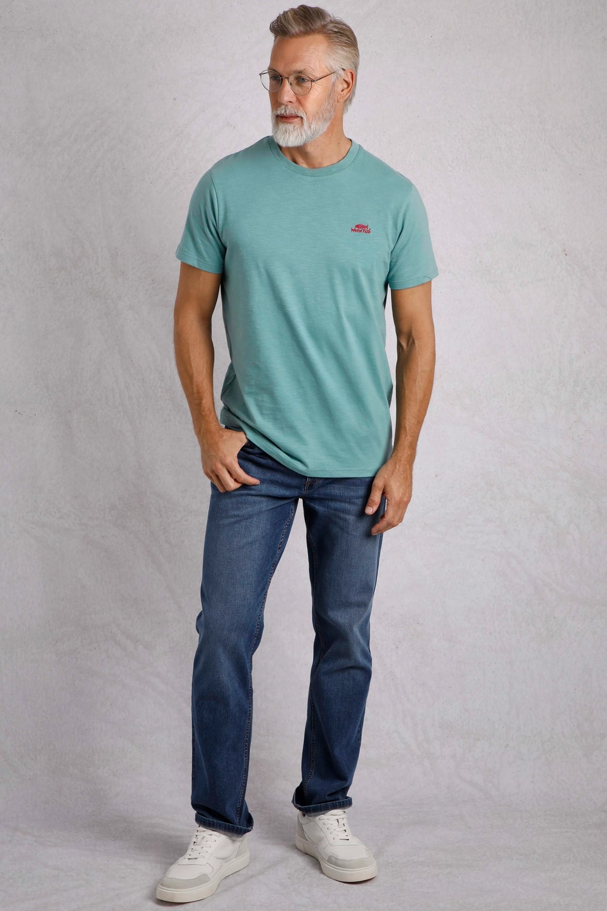 Weird Fish mens t-shirt blue worn by a mature man with jeans and white sneakers
