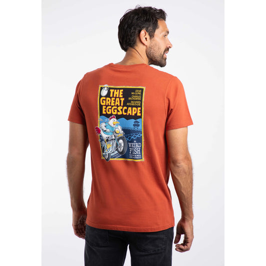 Man wearing an orange t-shirt with a graphic design on the back, standing against a white background.